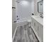 Bathroom featuring a shower over the tub, white vanity, and gray wood-style flooring at 2489 Smith Ave, Marietta, GA 30064