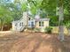 Charming home showcasing a front deck, neutral siding, complemented by a backdrop of mature trees and natural landscaping at 2489 Smith Ave, Marietta, GA 30064