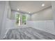 Well-lit room featuring modern grey flooring, white walls with paneling, and a large window at 2489 Smith Ave, Marietta, GA 30064