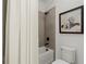 Neutral bathroom features a shower and tub, toilet, and cute dog art at 635 Opera Ln, Alpharetta, GA 30009