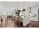 Open concept kitchen with stainless hood, island with seating, seamlessly flowing into the living area at 635 Opera Ln, Alpharetta, GA 30009
