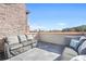 Relaxing rooftop patio featuring comfortable couches and a stunning city view on a clear, sunny day at 1199 Huff Nw Rd # 112, Atlanta, GA 30318