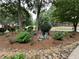 Charming front yard with rock garden, featuring a decorative bicycle surrounded by beautiful landscaping and mature trees at 3962 Fox Glen Dr, Woodstock, GA 30189