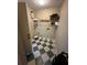 Small laundry room with a checkered floor, storage shelves, and a door at 3962 Fox Glen Dr, Woodstock, GA 30189