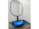 Chic bathroom vanity with a unique blue glass bowl sink, round mirror and granite countertop at 4179 Hanes Dr, Decatur, GA 30035