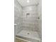 Modern shower stall featuring stone-look tiling, a built-in niche, and a mosaic tile floor at 4179 Hanes Dr, Decatur, GA 30035