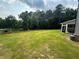 Wide backyard featuring lush green lawn, privacy fence, and mature trees at 495 Sterling Creek Way, Loganville, GA 30052
