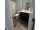Bathroom featuring a dark vanity, commode, a shower with light grey curtain, and dark grey rugs on the floor at 495 Sterling Creek Way, Loganville, GA 30052