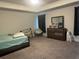 Spacious carpeted bedroom with tray ceiling, bed, ceiling fan, dresser, and window at 495 Sterling Creek Way, Loganville, GA 30052