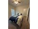 Bright bedroom featuring a bed with patterned bedding, neutral walls, and an adjacent doorway at 495 Sterling Creek Way, Loganville, GA 30052