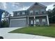 Charming two-story home featuring brick and gray siding, a two-car garage, and a well-manicured lawn at 495 Sterling Creek Way, Loganville, GA 30052