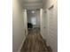 Inviting hallway with wood floors, neutral paint, and access to a dining area and white doors at 495 Sterling Creek Way, Loganville, GA 30052