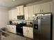 Well-equipped kitchen with white cabinets, granite counters, stainless steel appliances, and modern fixtures at 495 Sterling Creek Way, Loganville, GA 30052
