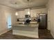 Stylish kitchen featuring granite countertops, white cabinets, stainless steel appliances, and a breakfast bar at 495 Sterling Creek Way, Loganville, GA 30052