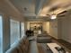 Comfortable living room with coffered ceilings, a ceiling fan, large windows, and open access to the kitchen at 495 Sterling Creek Way, Loganville, GA 30052