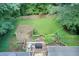 Aerial view of a backyard with a deck, pergola, grill, and a lush green lawn surrounded by trees at 652 Trailwood Sw Ln, Marietta, GA 30064