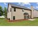 A home's backyard featuring green grass, vinyl siding, brick foundation, and a small patio at 8398 Members Dr, Jonesboro, GA 30236