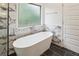 Spa-like bathroom with a freestanding tub, marble accents, and black tiled floors, providing relaxation at 8398 Members Dr, Jonesboro, GA 30236