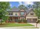 Charming two-story home featuring a well-manicured lawn, brick accents, and a two-car garage at 8398 Members Dr, Jonesboro, GA 30236