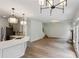 Open-concept living room and kitchen featuring modern lighting, light grey cabinets, and wood floor at 8398 Members Dr, Jonesboro, GA 30236