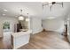 Open-concept living room and kitchen featuring modern lighting, light grey cabinets, and wood floor at 8398 Members Dr, Jonesboro, GA 30236