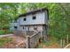 Back view of house with deck and wooded surroundings at 1352 Overlook Se Cv, Smyrna, GA 30080