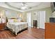 Spacious primary bedroom with a tray ceiling, hardwood floors, and ensuite bath at 408 Victoria Place Dr, Locust Grove, GA 30248