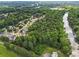 An aerial shot of houses surrounded by lush trees and a river, creating a serene and private community setting at 1950 Stethem Fry, Alpharetta, GA 30022