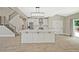 Open-concept kitchen with a large island, stainless steel appliances, and seamless flow to the living space and staircase at 1950 Stethem Fry, Alpharetta, GA 30022