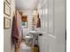 Cozy bathroom featuring a pedestal sink, toilet, framed art and a shower with stylish curtain and a neutral-toned color palette at 2119 Glenwood Se Ave, Atlanta, GA 30316