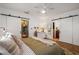 Bright bedroom with wood floors, barn door access to ensuite bathroom and walk-in closet, with a ceiling fan at 2119 Glenwood Se Ave, Atlanta, GA 30316