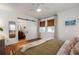 Bright bedroom featuring light walls, wood floors, a ceiling fan, and barn door to the bathroom at 2119 Glenwood Se Ave, Atlanta, GA 30316