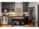 This updated kitchen offers stainless appliances, a butcher block island, and dark gray cabinets with glass-front accents at 2119 Glenwood Se Ave, Atlanta, GA 30316