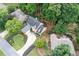 Aerial view of a charming home featuring a landscaped front yard, a circular driveway, and mature trees at 2192 Nine Oaks Nw Dr, Kennesaw, GA 30152