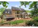 Expansive backyard features a covered patio, hot tub, mature trees, and landscaped garden beds for added curb appeal at 2192 Nine Oaks Nw Dr, Kennesaw, GA 30152