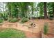 Beautiful backyard with mature trees, terraced landscaping, and a variety of plantings creates a serene outdoor space at 2192 Nine Oaks Nw Dr, Kennesaw, GA 30152