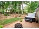Outdoor fire pit with an adjacent hot tub and bench seating surrounded by a wooded private backyard at 2192 Nine Oaks Nw Dr, Kennesaw, GA 30152