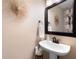 Charming powder room features a pedestal sink, decorative mirror, and a floral accent wall at 2192 Nine Oaks Nw Dr, Kennesaw, GA 30152