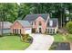 Beautiful brick home with lush landscaping, a circular driveway, and a well-manicured lawn at 2192 Nine Oaks Nw Dr, Kennesaw, GA 30152