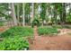 Exquisite backyard landscaping featuring stone steps and lush greenery leading to a trellised gate at 2192 Nine Oaks Nw Dr, Kennesaw, GA 30152