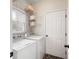 A practical laundry room complete with washer, dryer, storage shelves, and a window for natural light at 2192 Nine Oaks Nw Dr, Kennesaw, GA 30152