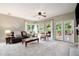 Bright living room featuring large windows, plush carpeting, and a comfortable seating area with view to the back yard at 2192 Nine Oaks Nw Dr, Kennesaw, GA 30152