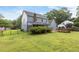 Back exterior of home with a deck and large backyard filled with lush green grass at 1433 Janice Sw Ct, Lilburn, GA 30047