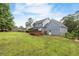 Back exterior view of house featuring a deck, large yard, and mature trees at 1433 Janice Sw Ct, Lilburn, GA 30047