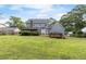 Exterior back view of house featuring deck, large yard, and mature trees at 1433 Janice Sw Ct, Lilburn, GA 30047