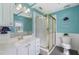Bright bathroom featuring a glass door shower, toilet, vanity mirror, and a window at 1433 Janice Sw Ct, Lilburn, GA 30047