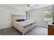 Bedroom with gray carpet, white wooden bed, ceiling fan, and natural lighting at 1433 Janice Sw Ct, Lilburn, GA 30047