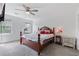 Spacious bedroom with a wooden bed frame, soft carpet, a ceiling fan, and natural lighting at 1433 Janice Sw Ct, Lilburn, GA 30047
