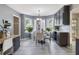 Bright dining area with elegant chandelier, large windows, and views to the kitchen at 1433 Janice Sw Ct, Lilburn, GA 30047