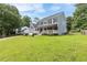 Two-story home with a large front lawn, inviting covered porch, and mature trees at 1433 Janice Sw Ct, Lilburn, GA 30047